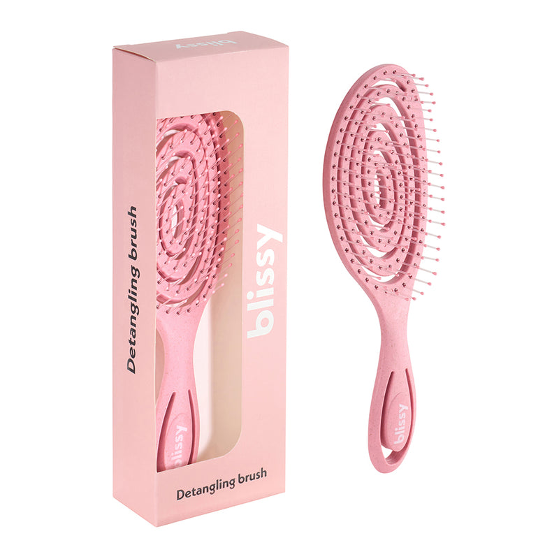 Pink detangling brush with packaging on a white background